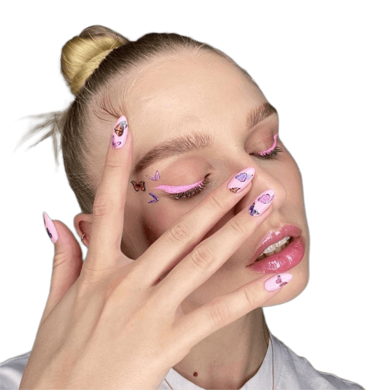 Дівчина з рожевою підводкою на очах має біля брови такі ж наліпки, як і на рожевих нігтях, що вона піднесла до обличчя