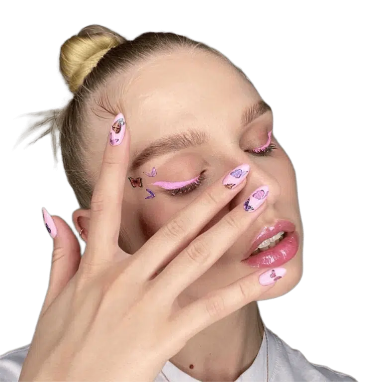 Дівчина з рожевою підводкою на очах має біля брови такі ж наліпки, як і на рожевих нігтях, що вона піднесла до обличчя