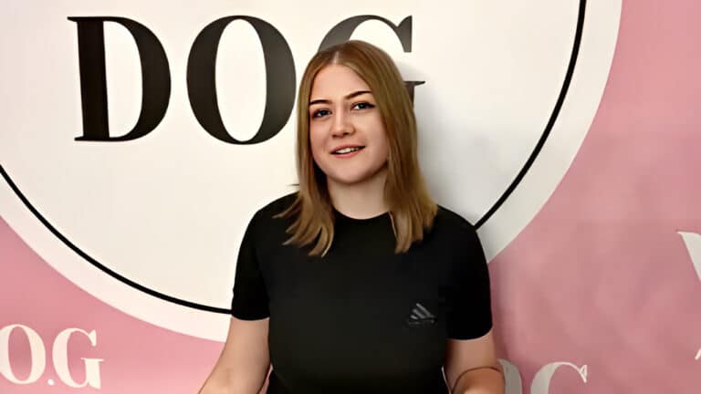 Чорна футболка на дівчині пасує до кольору її брів та логотипу на стіні