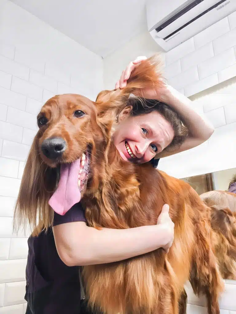 Грумерка обійняла за передні лапи спанієля і підняла одне вушко, щоб визирнути з посмішкою