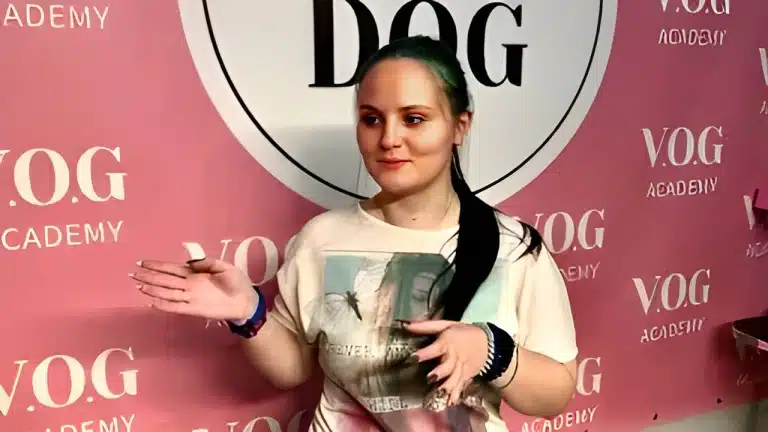 Дівчина з купою аксесуарів на руках активно жестикулює під час розмови