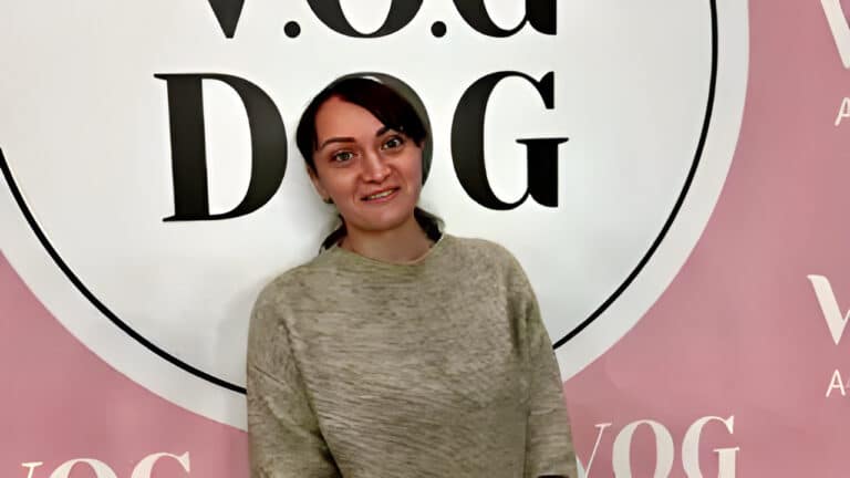 Дівчина в бежевому светрі закрила головою літеру "О"