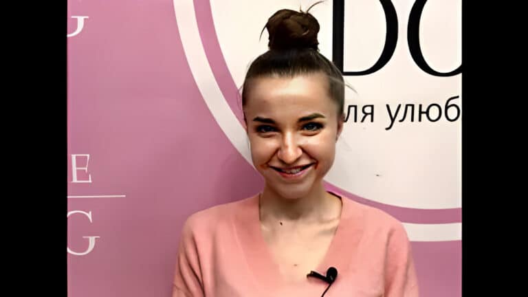 Дівчина з об'ємною гулькою має прикріплений мікрофон на рожевій кофті для інтерв'ю