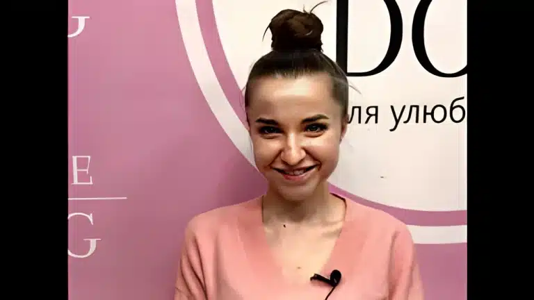 Дівчина з об'ємною гулькою має прикріплений мікрофон на рожевій кофті для інтерв'ю