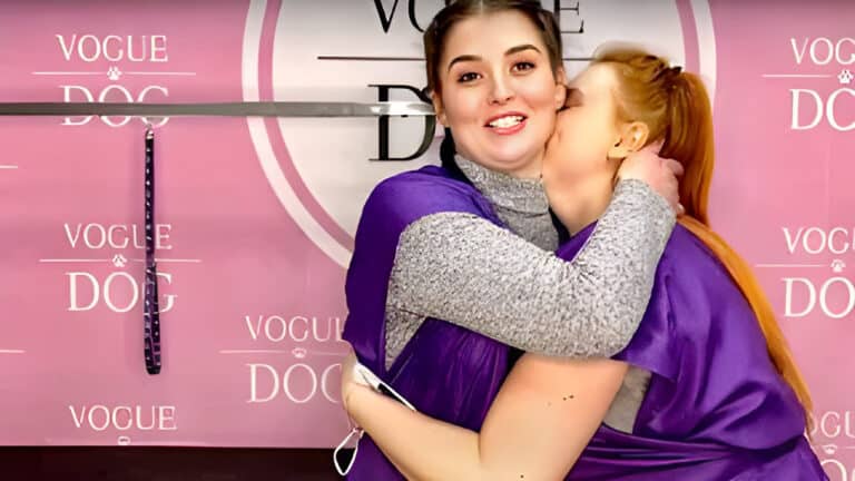 Рудоволоса дівчина цілує в шию іншу дівчину біля грумерського стола з фіолетовою ринговкою