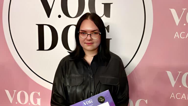 Дівчина в окулярах вдягнута в чорну шкіряну сорочку, що пасує до кольору волосся