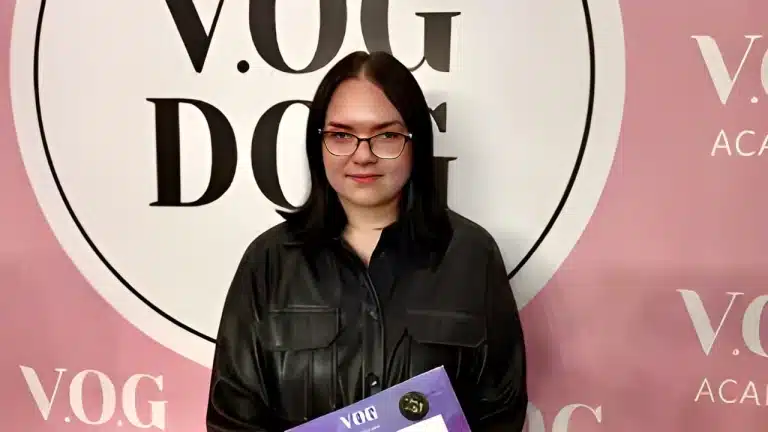 Дівчина в окулярах вдягнута в чорну шкіряну сорочку, що пасує до кольору волосся