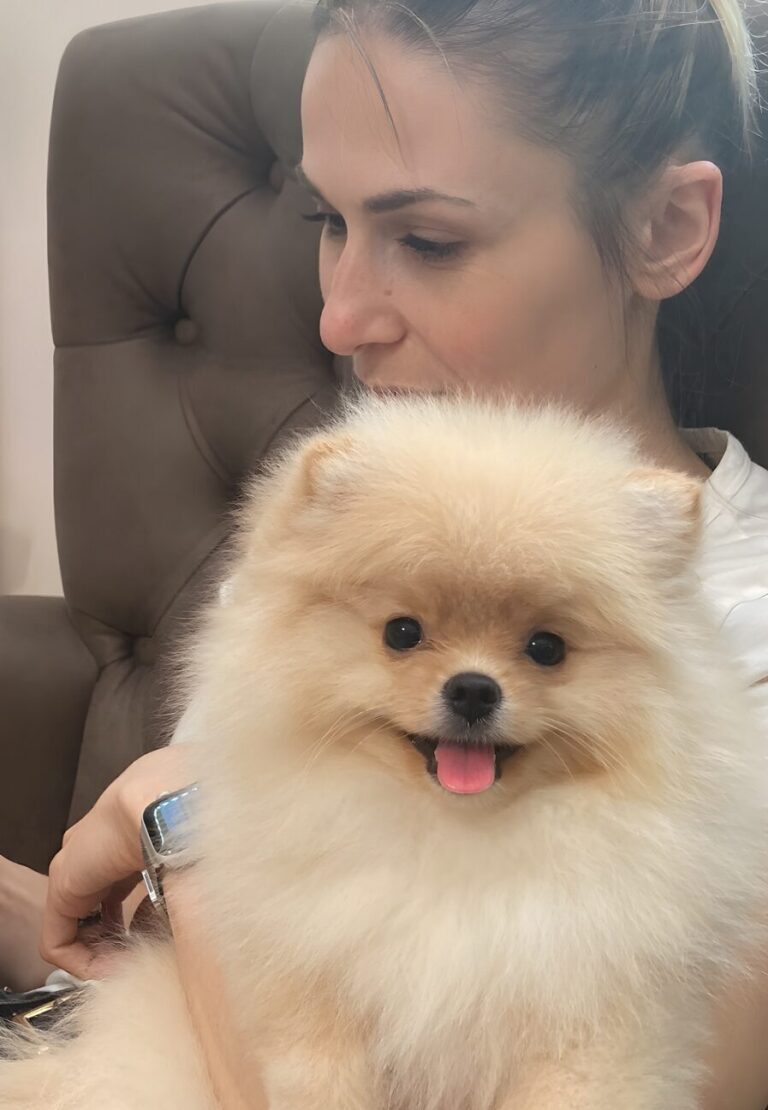 Дівчина дивиться кудись в бік, а шпіц, що сидить на її руках, - прямо в камеру