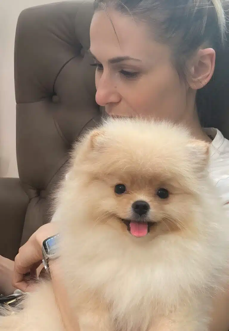 Дівчина дивиться кудись в бік, а шпіц, що сидить на її руках, - прямо в камеру