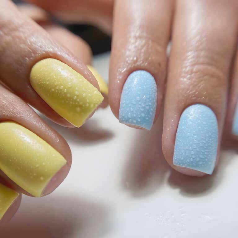 Жовті та блакитні нігтики зверху вкриті крапельками води