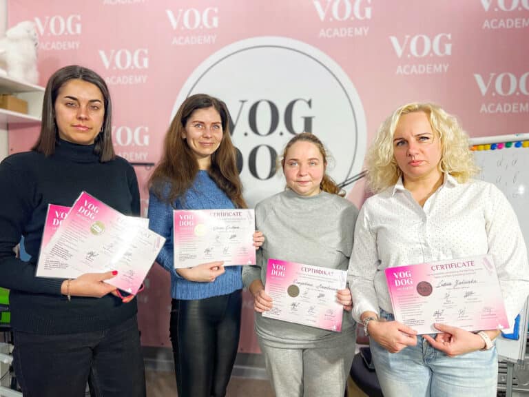 Чотири випускниці Академії грумінгу тримають в руках заповітні сертифікати про закінчення навчання