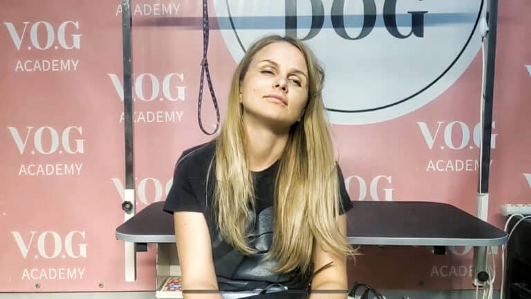 Дівчина нахилила голову назад та прикрила очі, сидячи перед грумерським столом