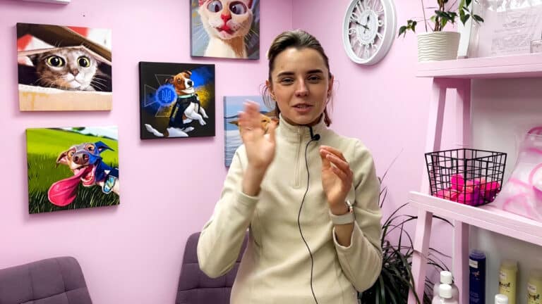 Дівчина в бежевій флісці з прикріпленим мікрофоном щось розповідає, активно жестикулюючи