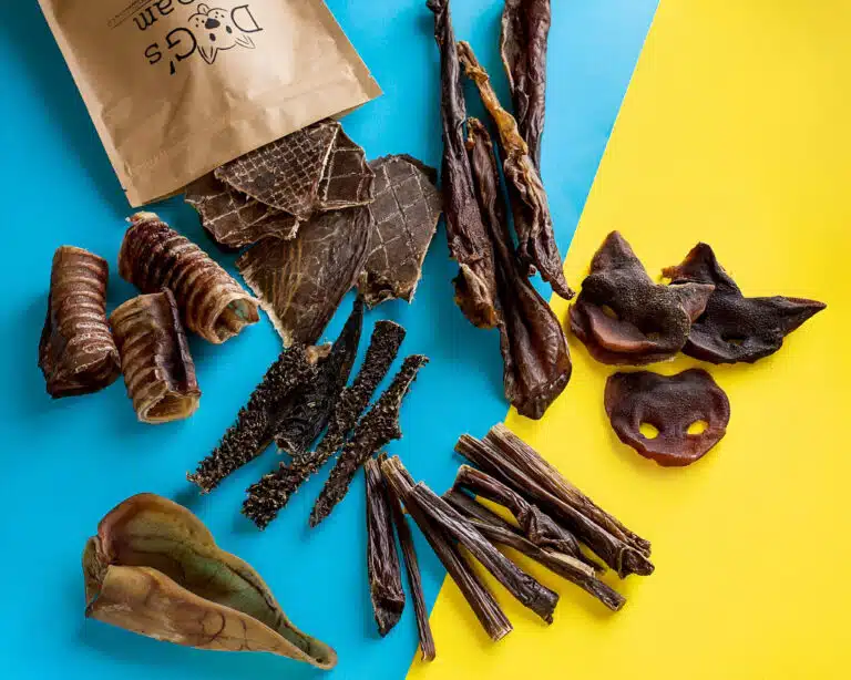 На жовто-блакитному фоні розкладені з крафтового пакета засушені натуральні смаколики