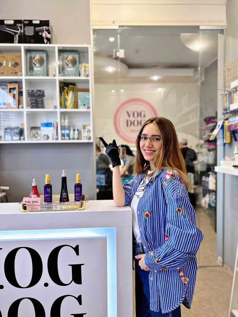 Дівчина в чорній рукавиці перевіряє на чистоту приймальню грумінг-салону