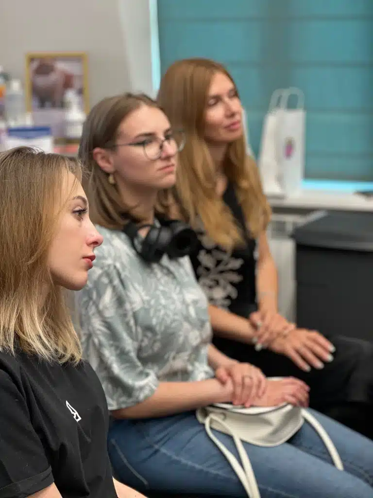 Дівчина в окулярах прийшла на семінар з білою сумкою та чорними великими навушниками