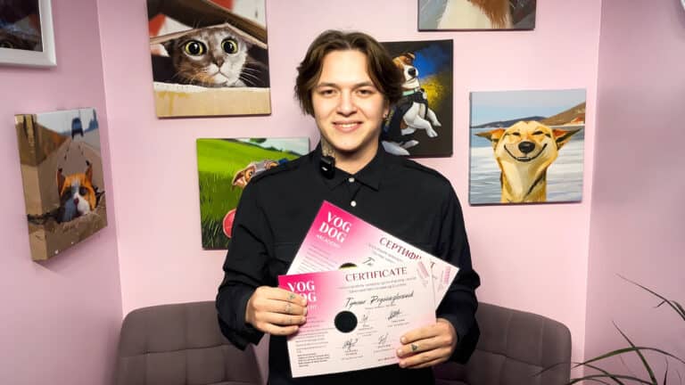Хлопець в чорній сорочці тримає сертифікати про завершення грумінг-курсів