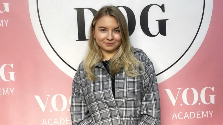 Волосся дівчини в картатій сорочці заправлене за праве вухо