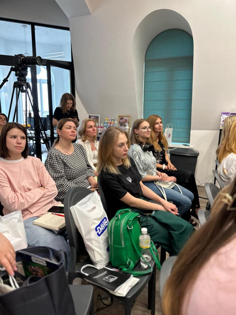 Пустий стілець серед аудиторії зайняли пакет, пляшка води та зелений рюкзак