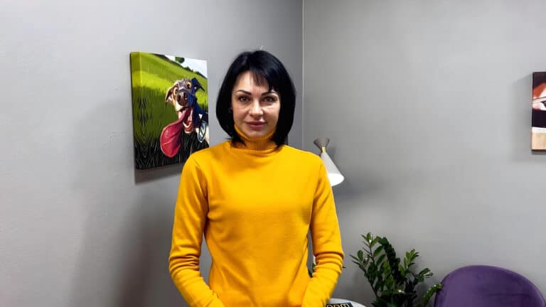 Жінка в жовтій водолазці має чорне каре