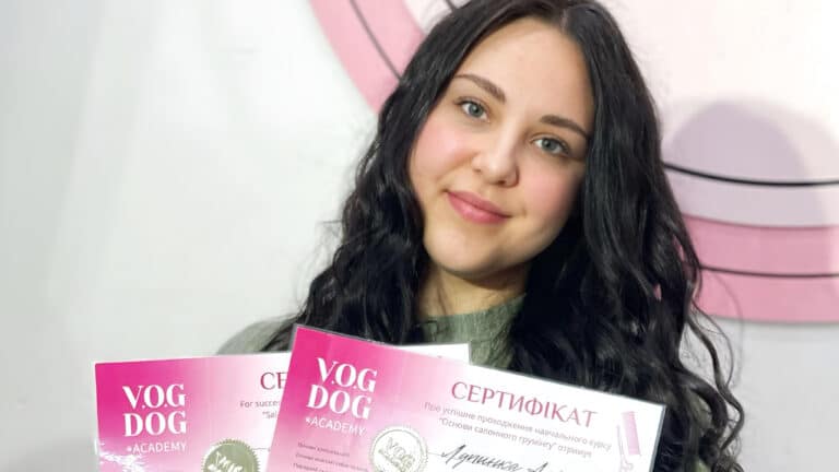 Волосся дівчини, що тримає сертифікати, в кудрях