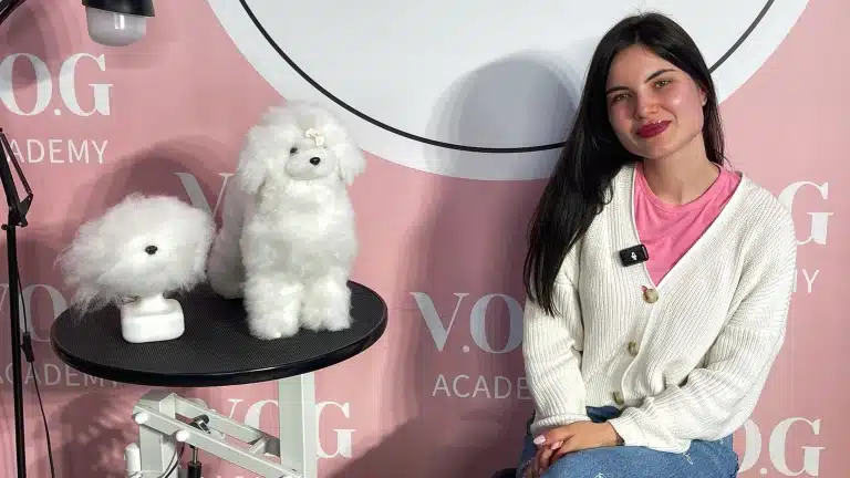 Дівчина з темним волоссям вдягнута в рожеву футболку, білу кофтинку та світлі джинси