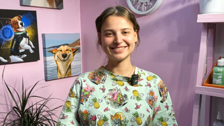 Дівчина в кофтині з ананасовим принтом широко всміхається