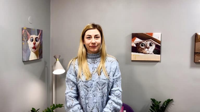 Дівчина з пофарбованим світлим волоссям одягнута в блакитний мереживний светр