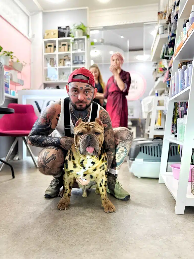 Власник у червоній кепці присів біля свого стаффа, демонструючи фарбування