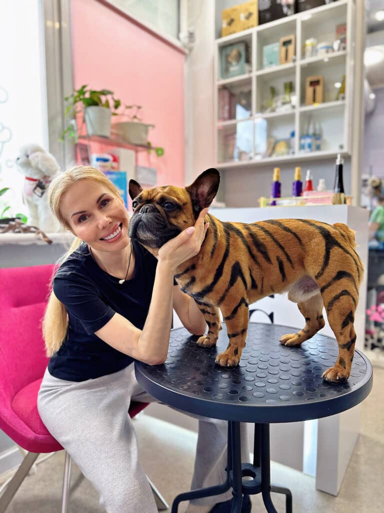 Блондинка обіймає бульдога після завершення фарбування у тигра