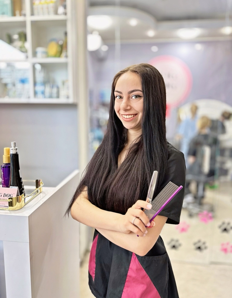 Грумер схрестила руки перед дверима грумерської