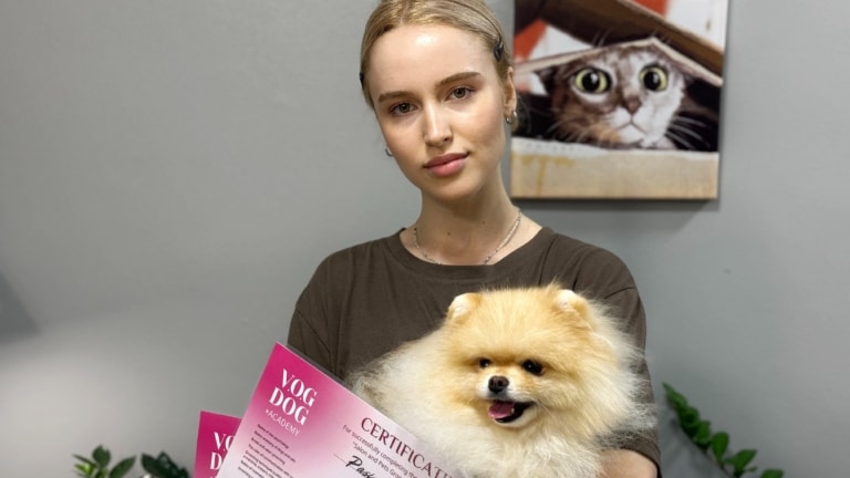 Дівчина з зібраним волоссям тримає шпіца, що дивиться в бік