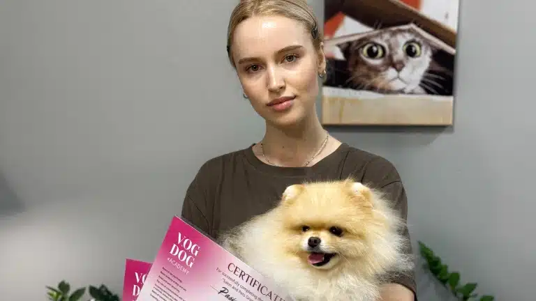 Дівчина з зібраним волоссям тримає шпіца, що дивиться в бік