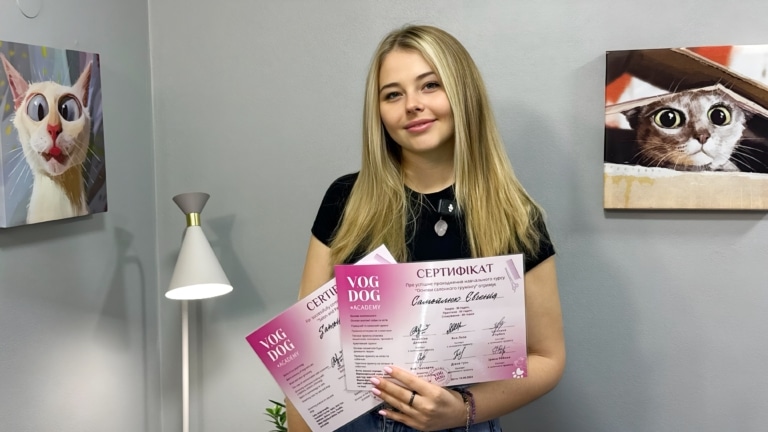 Дівчина посміхається з отриманими сертифікатами в руках