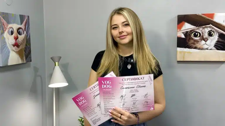 Дівчина посміхається з отриманими сертифікатами в руках