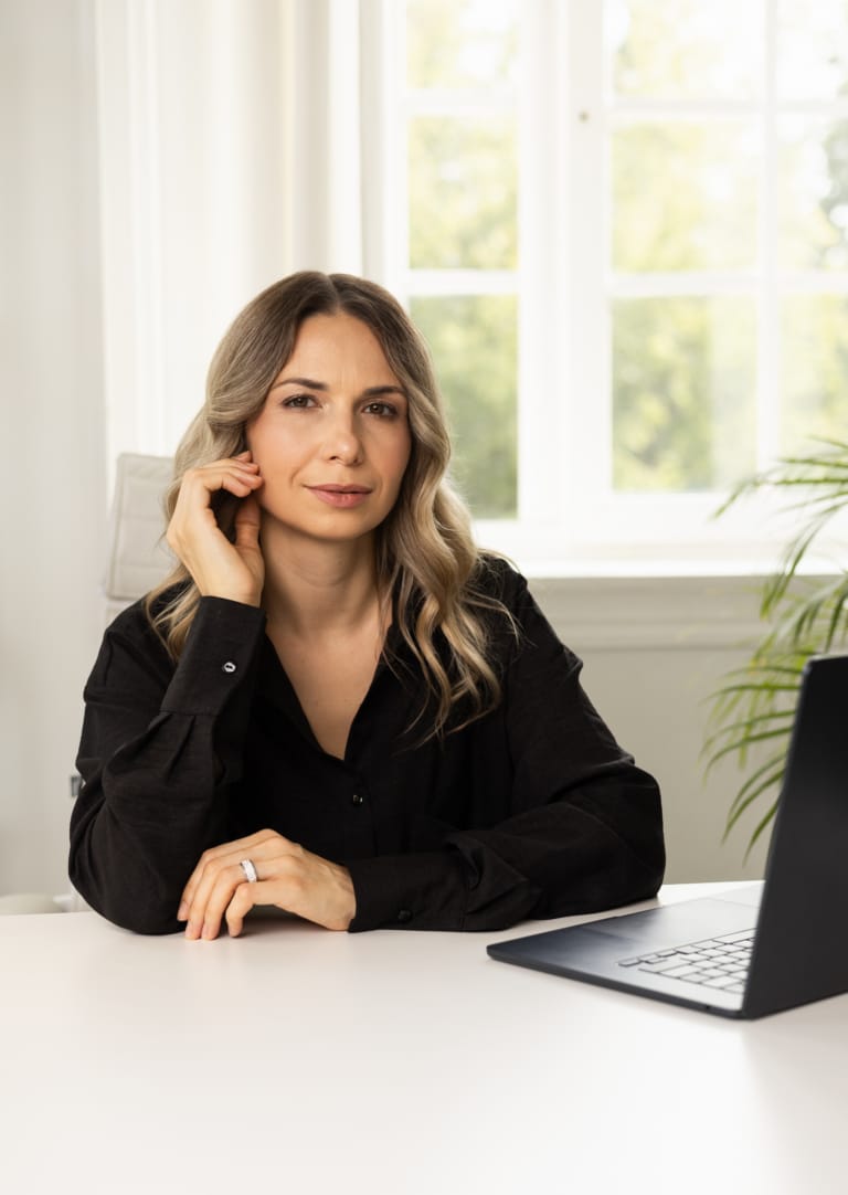 Бізнес-леді задумалась біля чорного ноутбуку