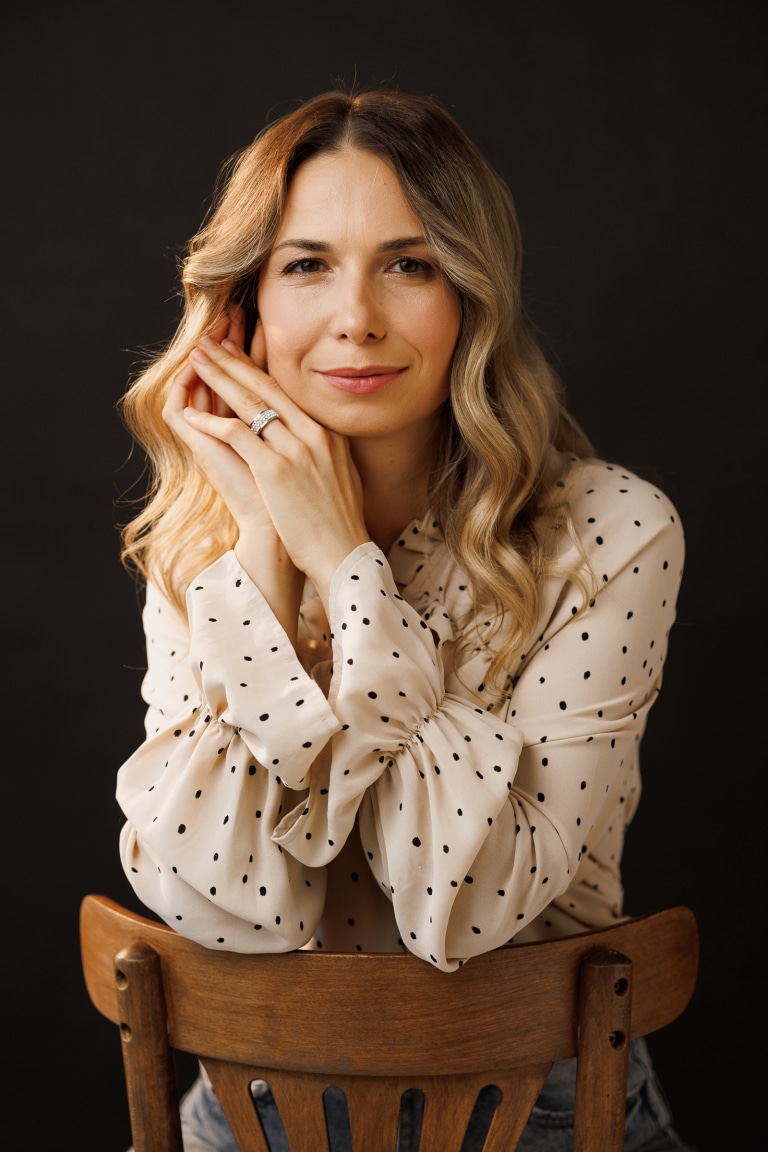 Дівчина з хвилястою зачіскою ніжно посміхається на фотосесії