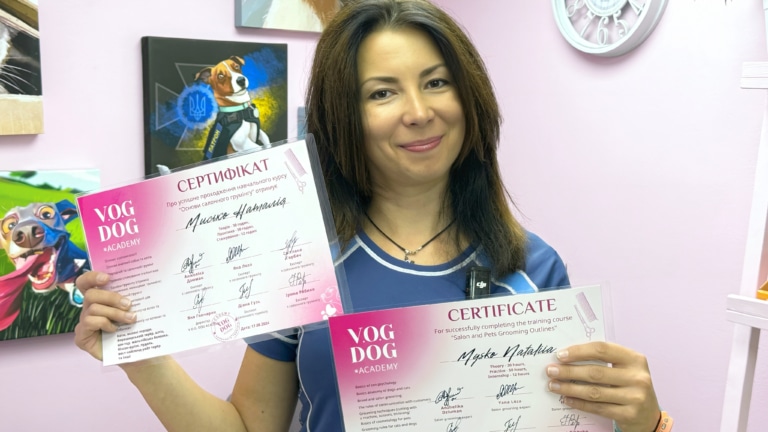 Задоволена студентка тримає в руках сертифікат про закінчення курсів