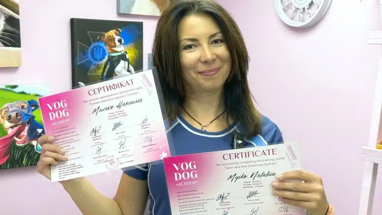 Задоволена студентка тримає в руках сертифікат про закінчення курсів