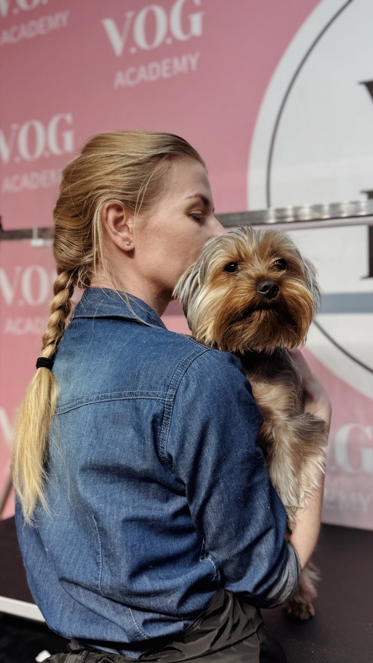 Дівчина цілує йорка в голівку, а той від задоволення притис вушка