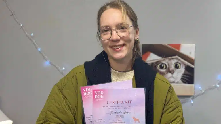 Дівчина в окулярах з тонкою оправою посміхається після складення іспиту з грумінгу