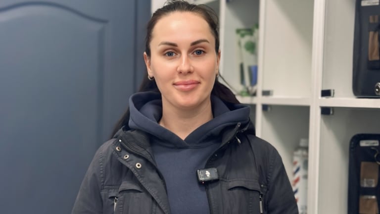 Дівчина з хвостиком вдягнена у синю кофту та чорну куртку