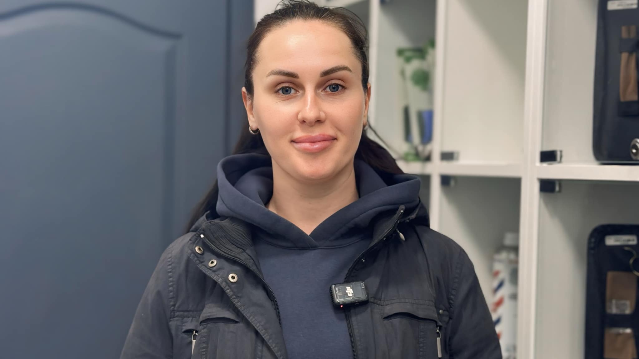 Дівчина з хвостиком вдягнена у синю кофту та чорну куртку