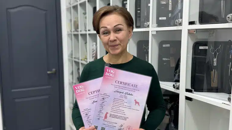 Жінка з тонкими намальованими бровами тримає в руках два рожевих сертифікати