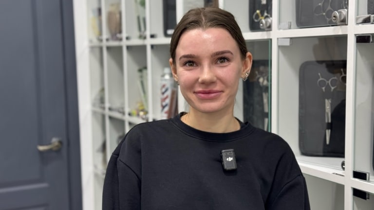 Дівчина в чорному худі має три сережки на лівому вусі