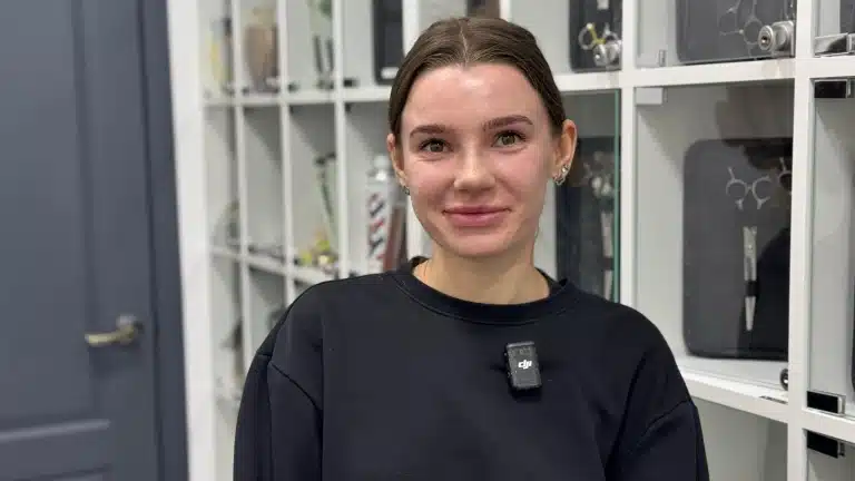 Дівчина в чорному худі має три сережки на лівому вусі