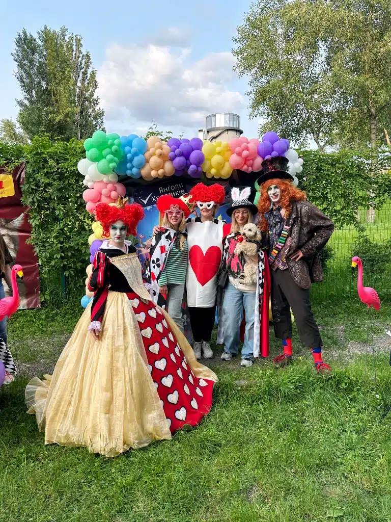 Люди, вдягнуті в казковому стилі, стоять під повітряними кулями