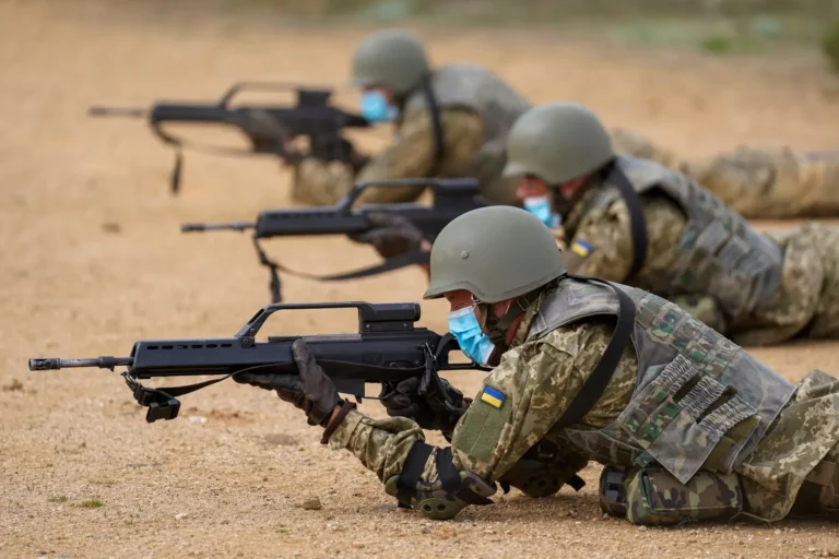 Військові у синіх захисних масках лягли на землю та стріляють