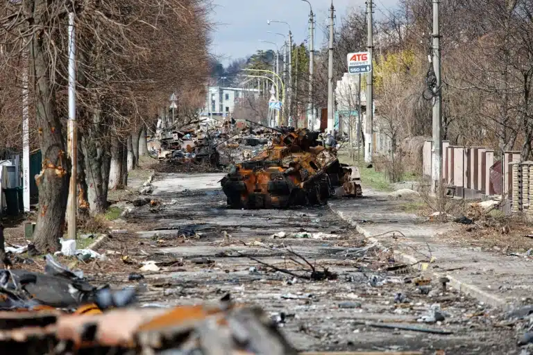 Вулиця з купою сміття та знищеним танком